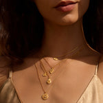 A model wearing multiple layers of spiritual jewelry, including the Shielded Spirit White Topaz Evil Eye Necklace, showcasing its beautiful design and meaningful talisman for protection. This collection enhances meditation and manifestation rituals, harmonizing with themes of zodiac, sun, and moon.