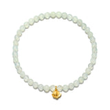 A circular stretch bracelet of small, faceted, pale green translucent beads with a single gold lotus flower charm hanging at the bottom.