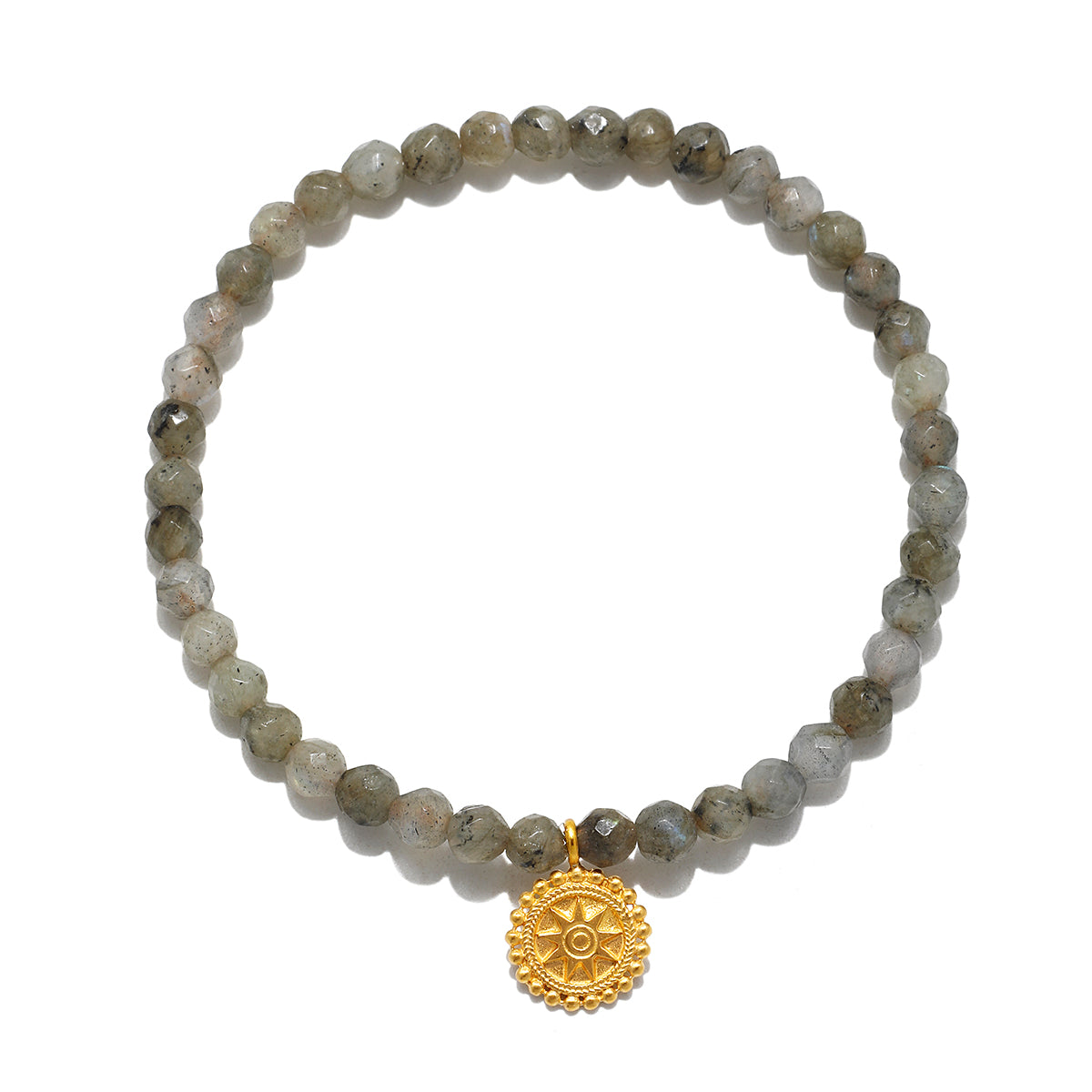 A circular stretch bracelet of small faceted gray-green beads with a round gold mandala charm hanging at the bottom.