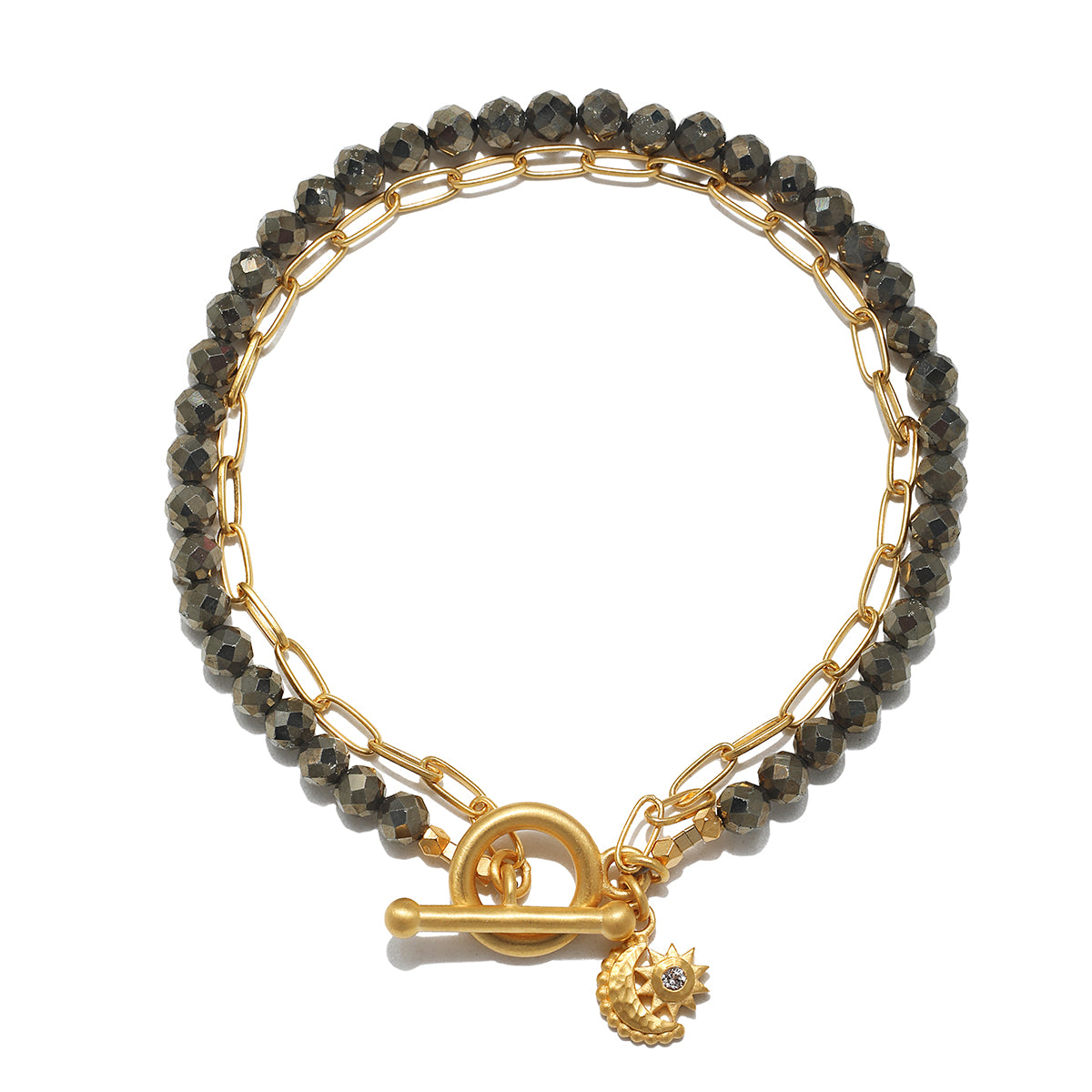 A bracelet pairs faceted dark pyrite beads with a gold paperclip chain, finished with a toggle clasp and a moon-and-sun charm.