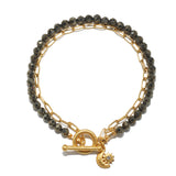 A bracelet pairs faceted dark pyrite beads with a gold paperclip chain, finished with a toggle clasp and a moon-and-sun charm.
