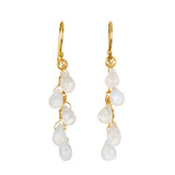 A pair of gold-toned hook earrings, each with a cascading cluster of five pale, translucent teardrop moonstone beads on wire.
