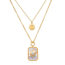Two-strand gold necklace set with small sun charm and rectangular pendant featuring sun motif with crystal center.