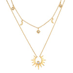 Two-layered gold necklace set with celestial charms including sun, moon, and star pendants with crystal accents.