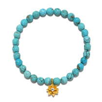 In Transformation Turquoise Gemstone Bracelet featuring a golden lotus flower charm. This spiritual jewelry embodies health, intuition, and self-expression, making it perfect for meditation and yoga practices. A meaningful talisman for manifestation and protection.