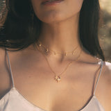 Two-piece gold necklace set with sun pendant and moon-and-star charm chain worn on model.