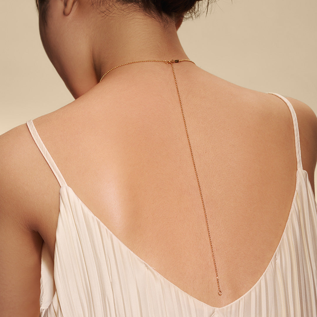 Back view of a woman wearing a single Aquarius Zodiac Necklace, highlighting its elegant simplicity. This spiritual jewelry serves as a meaningful talisman, embodying the essence of astrology while offering protection during meditation, making it a perfect addition for yoga practices.