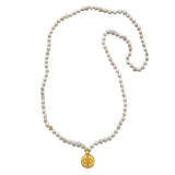 The Aligned in Intention White Turquoise Chakra Mala displayed flat against a clean background, highlighting the 108 white turquoise beads and the stunning gold plate pendant. This spiritual jewelry piece is perfect for enhancing meditation practices and serves as a powerful talisman for protection and meaningful energy flow.