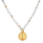 Aligned in Intention White Turquoise Chakra Mala featuring 108 white turquoise beads and a golden pendant. This spiritual jewelry piece promotes meditation and serves as a meaningful talisman for protection and manifestation. Ideal for yoga practitioners, this mala symbolizes balance and aligns with the energies of the chakras for spiritual growth.