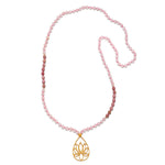 The Bloom In Love Rose Quartz Lotus Mala features 108 hand-beaded rose quartz beads, symbolizing unconditional love and compassion. Anchored by a gold-plated lotus flower, this spiritual jewelry piece serves as a beautiful talisman for meditation and manifestation practices. Perfect for yoga enthusiasts and those seeking spiritual protection, this mala embodies meaning and charm.