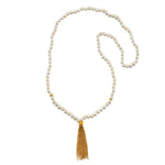 Beaded mala necklace with cream mother of pearl beads, gold spacer accents, and gold tassel pendant.