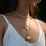 A model showcasing layered necklaces, including the Renewed Hope Pearl Butterfly Necklace, illustrating the beauty of spiritual jewelry for zodiac enthusiasts, highlighting their significance in protection, manifestation, and yoga practices.