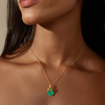 Gold chain necklace with green onyx pendant wrapped in gold wire detail.