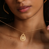 Open to Possibilities Lotus Necklace worn by a woman, featuring a delicate teardrop pendant with a lotus flower, symbolizing new beginnings and infinite potential. Ideal for spiritual jewelry enthusiasts, this necklace serves as a beautiful talisman for meditation, manifestation, and protection while embracing the meanings of sun, moon, and yoga.