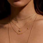 A model wearing the Soul Renew Gold Lotus Necklace layered with other gold chains. This spiritual jewelry piece embodies the essence of protection and charm, ideal for those who value meditation and the deeper meanings of zodiac energy in their lifestyle.