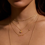 A model wearing the Soul Renew Gold Lotus Necklace layered with other gold chains. This spiritual jewelry piece embodies the essence of protection and charm, ideal for those who value meditation and the deeper meanings of zodiac energy in their lifestyle.