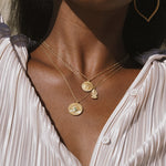 A model showcases the Prosperous Blessings Lakshmi Necklace layered with other gold necklaces, emphasizing the beauty of spiritual jewelry. This collection is perfect for embracing abundant energies in meditation, serving as a meaningful talisman for protection and manifestation.