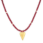 The Healing Heart Red Onyx Heart Necklace displayed against a white background, highlighting its vibrant red onyx beads and golden heart pendant. This piece of spiritual jewelry is perfect for those seeking protection and strength in their yoga and meditation journey.