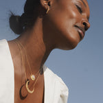 Close-up of the Cradled in Light Moonstone Necklace layered with other fine jewelry, highlighting its celestial beauty and significance in spirituality, making it a perfect talisman for yoga, meditation, and manifestation.
