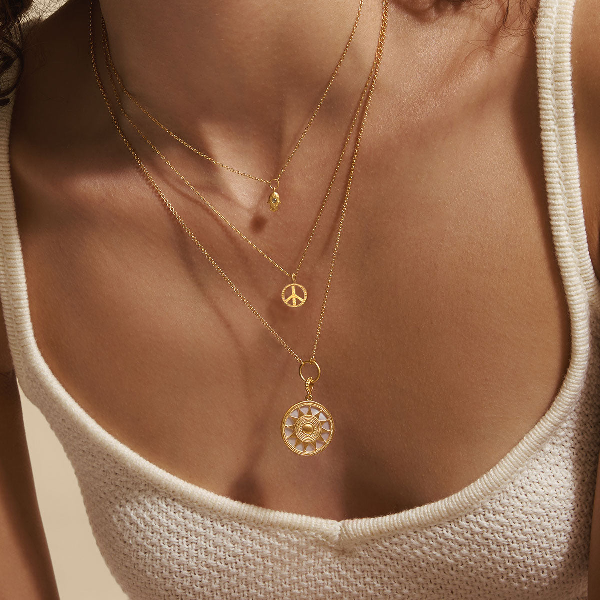 A close-up of the In Pursuit of Peace Necklace layered with other jewelry pieces, reflecting spirituality and meaningful vibes for yoga and protection.