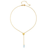 Flat lay of the Speak with Strength Chakra Lariat Necklace displaying its elegant design with blue topaz and gold plating, highlighting its meaning as spiritual jewelry and a meditation talisman for those seeking balance.