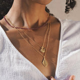 Model wearing the Grounded in Positivity Red Garnet Root Chakra Choker, layered with other meaningful spiritual jewelry pieces, showcasing its beauty and connection to meditation, astrology, and the energy of the sun and moon.