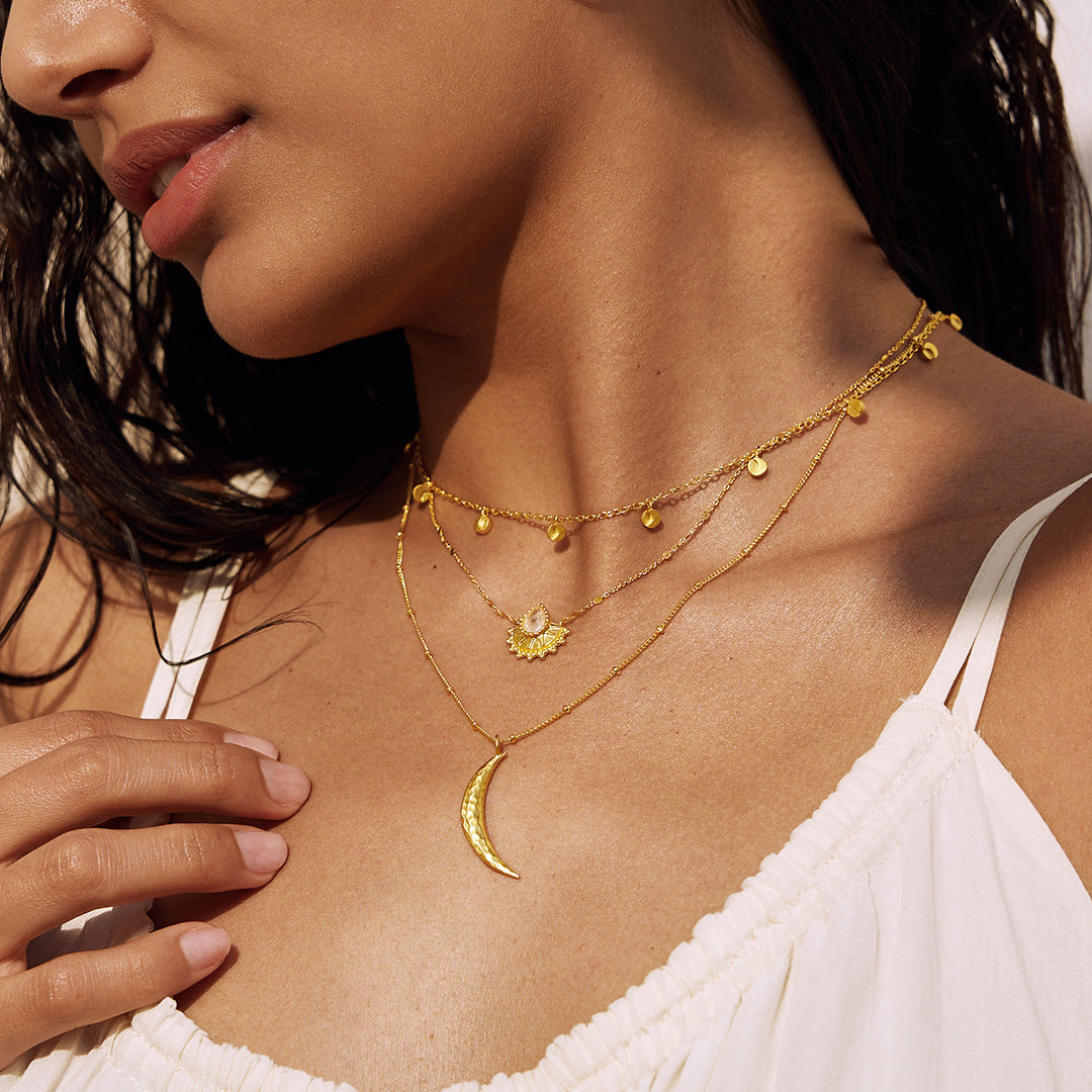 Close-up of the layered necklace arrangement including the Majestic Light Moonstone Necklace, radiating spiritual energy with symbols of sun, moon, and protection in a yoga-inspired style.