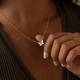 Close-up of the Renewed Hope Pearl Butterfly Necklace as a person gently touches the butterfly pendant, highlighting its significance in spiritual practices. This talismanic accessory is perfect for meditation, representing hope and transformation in a meaningful way for yoga enthusiasts.