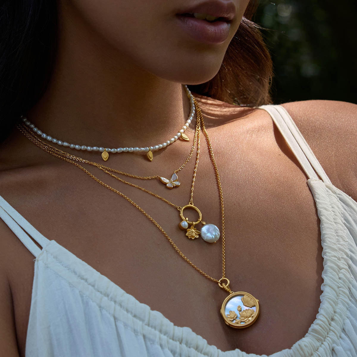 Layered look featuring the Blooming Promise Lotus Pearl Necklace among other jewelry, highlighting its beauty as a spiritual talisman for harmony and renewal, suitable for both everyday wear and special meditation sessions.