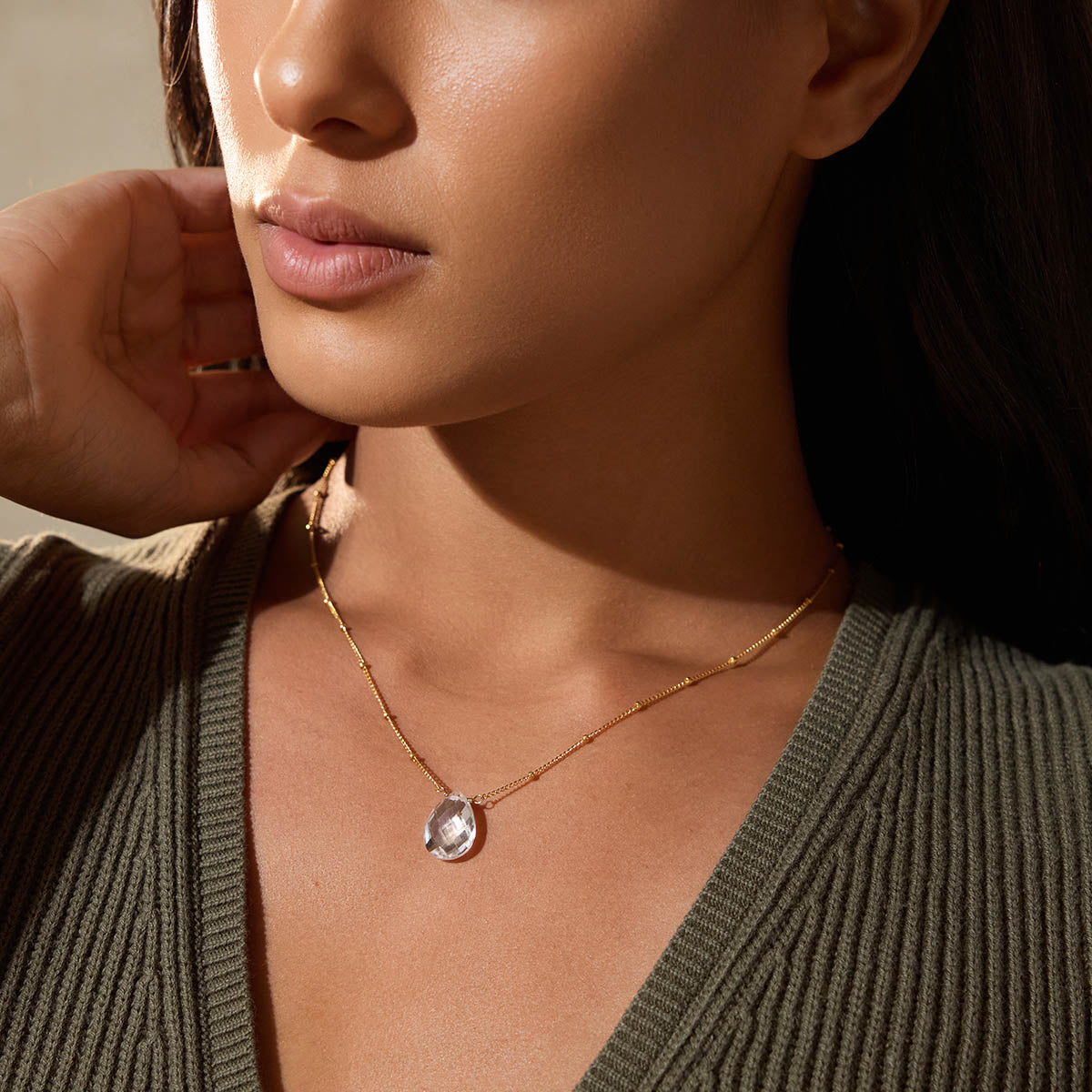 A close-up of a model wearing the Enveloped in Protection Crystal Necklace, featuring a beautiful crystal quartz pendant that enhances spirituality and serves as a meaningful talisman for yoga and zodiac practices.