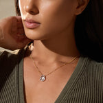 A close-up of a model wearing the Enveloped in Protection Crystal Necklace, featuring a beautiful crystal quartz pendant that enhances spirituality and serves as a meaningful talisman for yoga and zodiac practices.