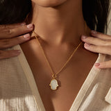 The back view of the Gaining Clarity White Topaz and Mother of Pearl Hamsa Reversible Necklace reveals its elegant design, embodying spiritual symbolism. This piece is ideal for manifestation and serves as a protective talisman for those practicing yoga and mindfulness.