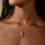 Close-up of a woman wearing the Inner Knowing Labradorite Snake Necklace, capturing the elegance of the gold snake design and labradorite stone. This spiritual jewelry serves as a meditation aid and a talisman, embodying meanings of renewal and protection in yoga practices.