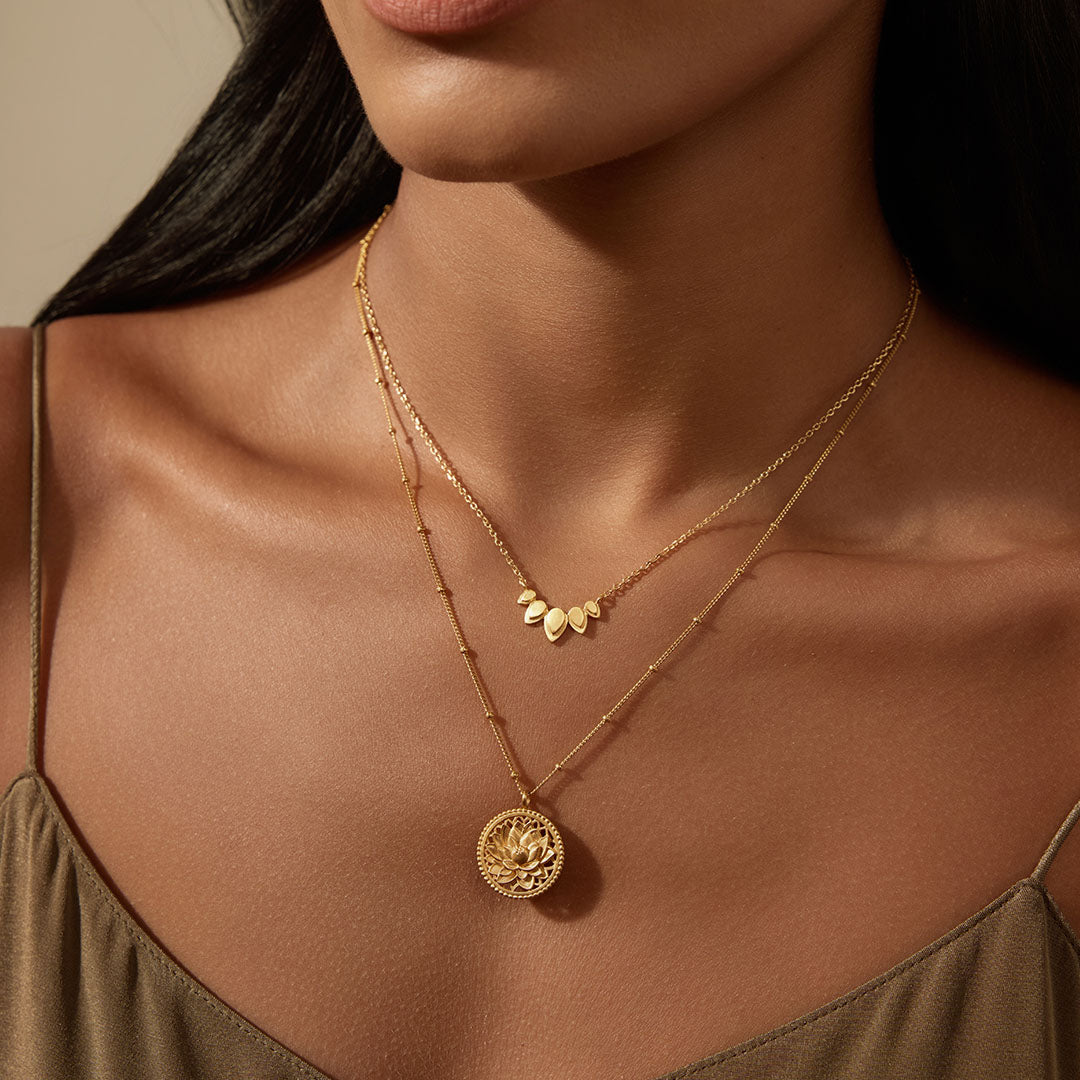 Model showcasing the Intention of Infinite Potential Necklace Set with a gold lotus pendant and layering chain, embodying spirituality and protection while promoting reflection during yoga and meditation practices.
