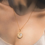 A model showcases the Waking Dreams Mother of Pearl Celestial Necklace, an elegant piece of spiritual jewelry that radiates harmony and wisdom. This meaningful talisman is ideal for meditation, embodying the essence of the zodiac with its celestial design, perfect for manifestation and protection during yoga.