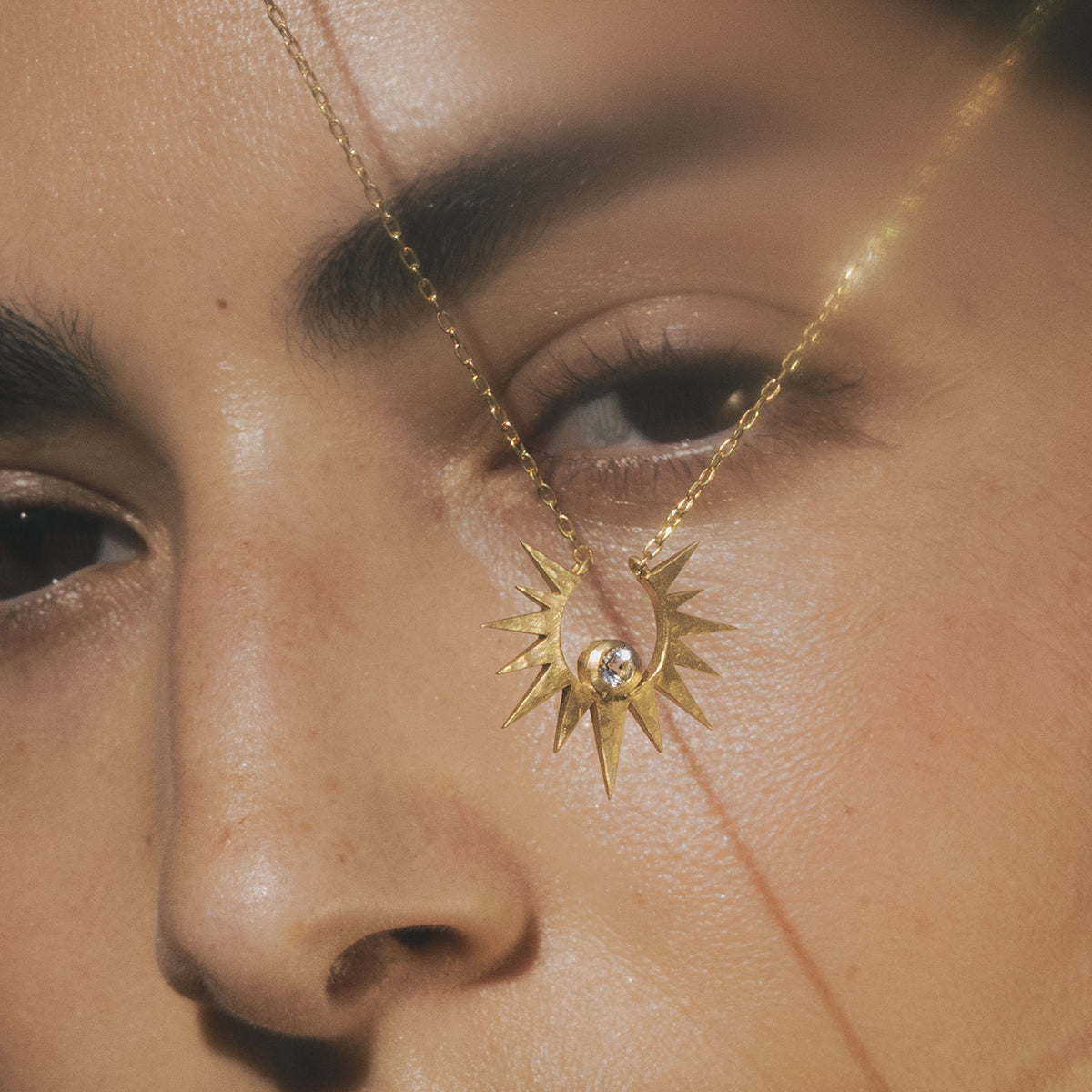 Close-up of the Unveiling Dreams White Topaz Starburst Necklace on a model, highlighting its intricate design and white topaz stone, representing spiritual connection and meaningful protection in meditation and yoga.