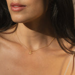 A close-up of a person wearing the Guiding Star Celestial White Topaz Necklace, featuring a charming crescent moon and white topaz stone. This spiritual jewelry piece enhances meditation and empowers manifestation, perfect for those seeking protection and meaningful connections in their zodiac and yoga journey.
