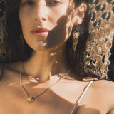 Close-up of the Scattering Stardust Labradorite Moon Fringe Necklace on a model, highlighting its shimmering labradorite and gold details. This meaningful piece of spiritual jewelry serves as a talisman for manifestation, connecting the wearer to both sun and moon energies, ideal for meditation and yoga.