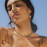 A serene image of a woman showcasing the Channeling Wisdom Sapphire Starburst Beaded Choker layered with other jewelry, embodying the essence of spiritual jewelry. This beautiful piece highlights its role in yoga, meditation, and meaningful manifestation, radiating protection and wisdom.