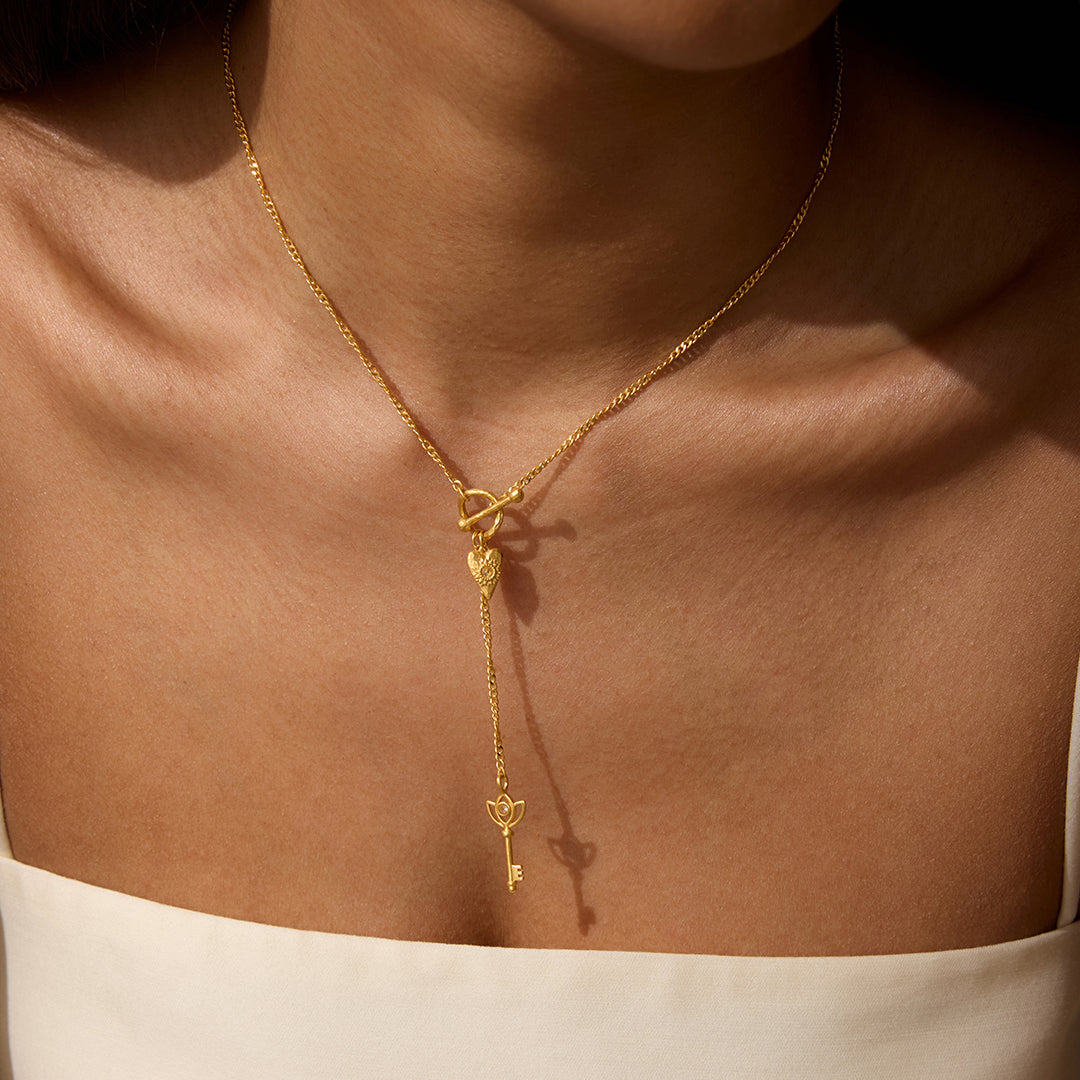 A close-up of the Promise to Love Heart Key Lariat Necklace worn on a woman's neck, showcasing its elegant design and spiritual symbolism, embodying love and manifestation, perfect for meditation and as a talisman for protection during yoga and mindfulness practices.
