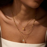 Woman wearing the Transformed by Love Tourmaline Agate Lotus Triple Necklace, highlighting the layers of colorful stones that symbolize spiritual connection, ideal for those interested in talismans, zodiac meanings, and protection during yoga and meditation.