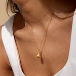 Model wearing the Love Potion Lotus Vessel Necklace, showcasing its elegant design on a delicate chain, symbolizing new beginnings. This spiritual jewelry piece serves as a talisman for protection and meaningful meditation, ideal for those interested in zodiac elements and holistic wellness.