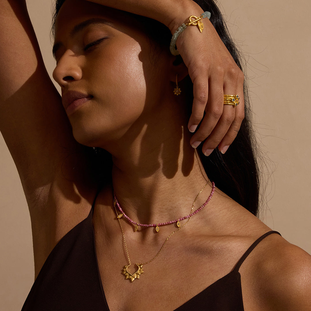 Woman adorned with the Transformed by Healing Rhodonite Lotus Petal Choker Necklace, reflecting spiritual essence and beauty, symbolizing new beginnings, perfect for meditation and yoga.