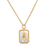 Gold-toned chain necklace with rectangular pendant featuring sun design and crystal center on light blue enamel background.