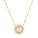 Gold-tone necklace with a sun-shaped pendant featuring a white iridescent moonstone center and beaded chain.