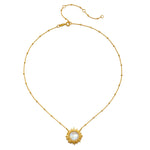 Gold-tone chain necklace with beaded links and a sun-shaped pendant featuring a white moonstone center.