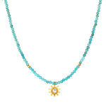 Turquoise bead choker necklace with gold-tone sun pendant featuring a center crystal stone.