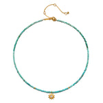 Turquoise beaded choker necklace with gold-tone sun pendant and adjustable chain closure.