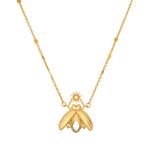 Gold-tone firefly pendant necklace with white topaz stone and beaded chain accents.