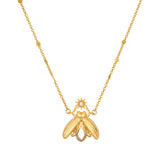 Gold-tone firefly pendant necklace with white topaz stone and beaded chain accents.